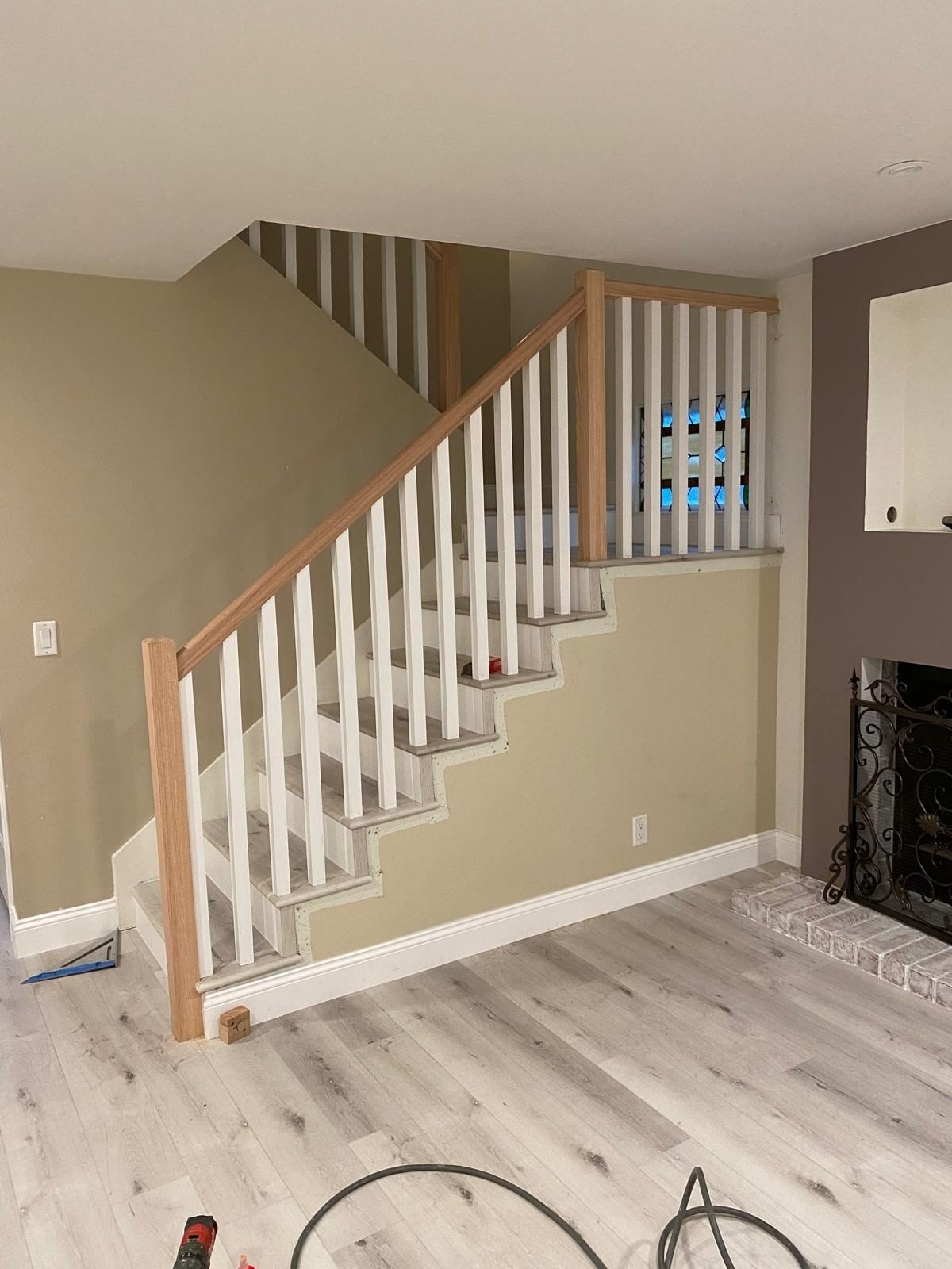 Staircase with continuous oak handrails on both sides and contrast tread nosings in a Torrance home